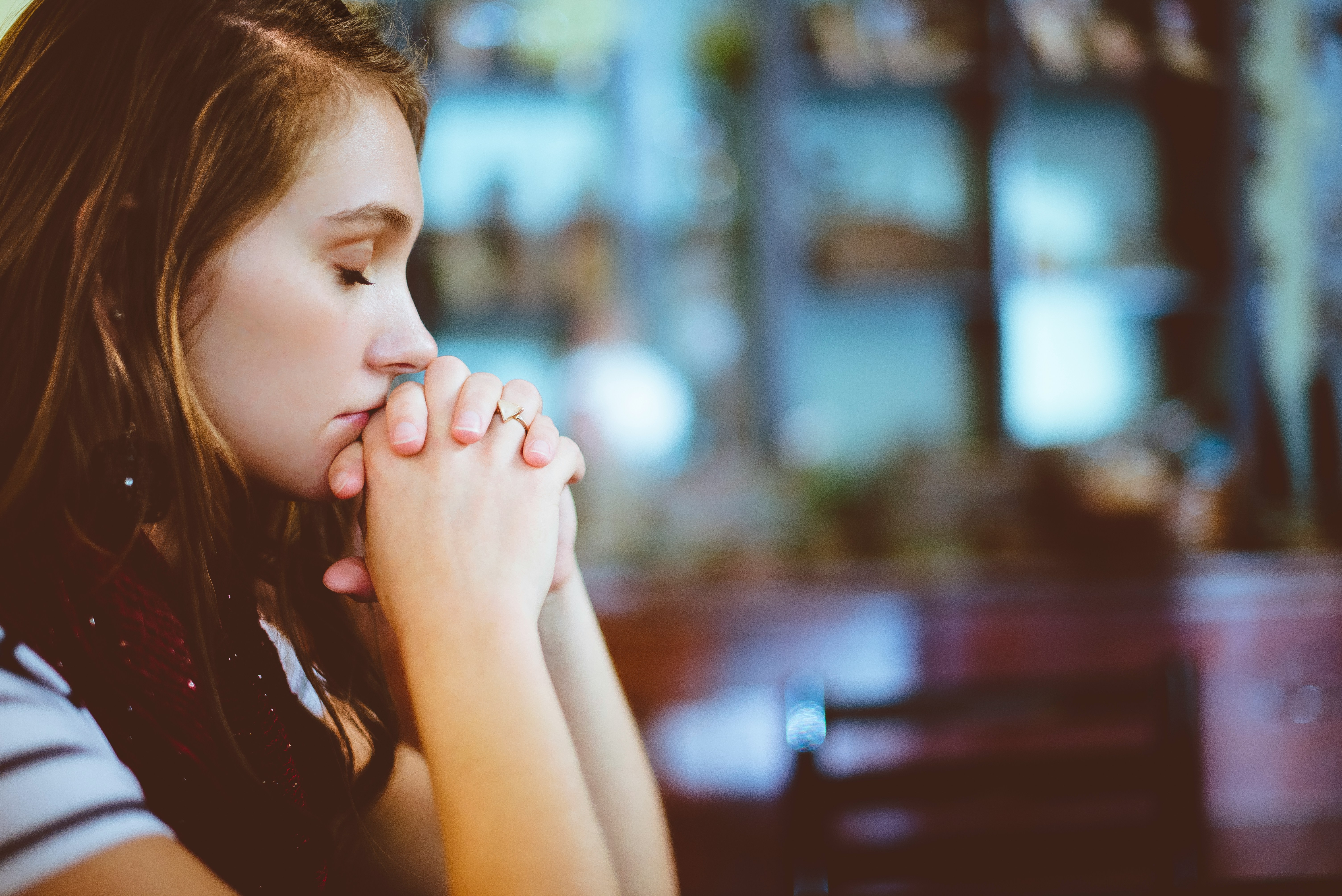 Woman with hands folded in sincere prayer